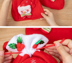 Détail du sac cadeau de Noël rouge avec bonhomme de neige en peluche et sequins houx