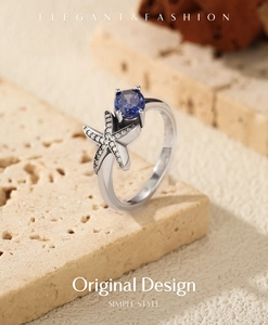 Macro shot of S925 sterling silver starfish ring with deep blue gemstone on stone base