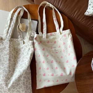 Detail shot of floral print cotton canvas tote bags on a wooden table with home decor