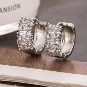 Macro detail of silver hoop earrings featuring baguette and round cubic zirconia pavé