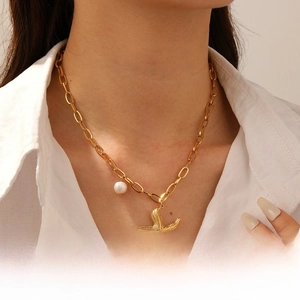Detail of gold starfish pendant with pearl on a chunky oval link chain necklace