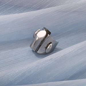 Detailed close-up of a minimalist silver stainless steel ring on blue fabric