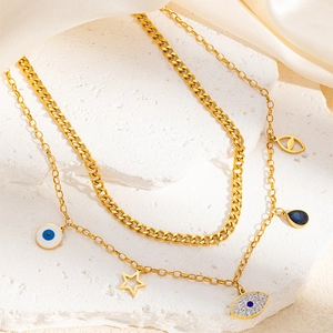 Détail du collier doré multicouche avec pendentifs mauvais œil, étoiles et gemmes