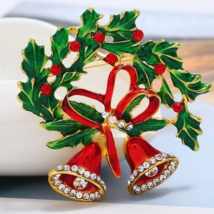 Detailed close-up of Christmas bell brooch with red crystals and green enamel leaves