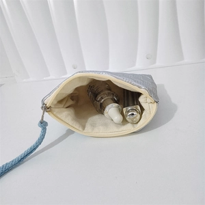 Detail view of silver quilted heart pouch with canvas lining for makeup storage
