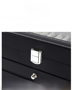 Macro shot of silver metal lock and white contrast stitching on black leather watch box