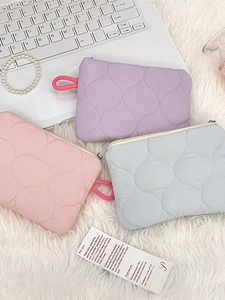 Quilted macaron-colored cosmetic bags with heart-shaped texture on white faux fur