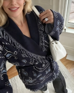 Detail of navy paisley knit cardigan with bohemian fringe trim and intricate pattern