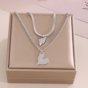 Double-layered stainless steel necklace with heart pendants on a jewelry display box