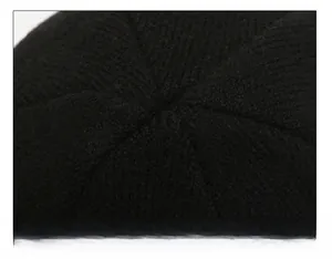 Macro view of detailed hexagonal top stitching on the black winter knitted beanie hat
