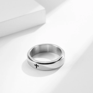 Macro shot of silver spinner ring featuring a black cross on the rotating outer band
