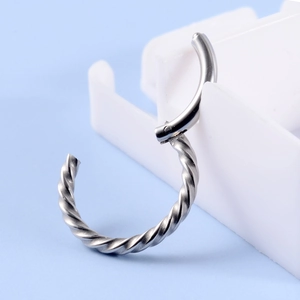 Detail of silver twisted rope hoop earring with a polished finish and hinged closure
