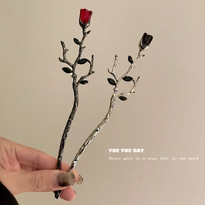 Detail of gothic metal hair sticks featuring elegant red and black rose bud motifs