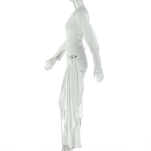 Détail de robe blanche à manches longues avec découpe latérale et fente haute drapée