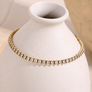 Détail d'un bracelet en zircon marquise plaqué or 18 carats sur un vase en céramique blanc