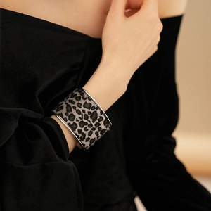 Close-up of wide leopard print bangle with silver metal edges on a velvet background