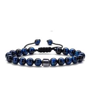 Dettaglio del bracciale con perline occhio di tigre blu, cordino nero intrecciato e cilindro