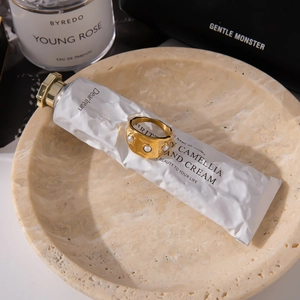 Detailed shot of a gold hammer-textured wide titanium steel ring with an inset pearl
