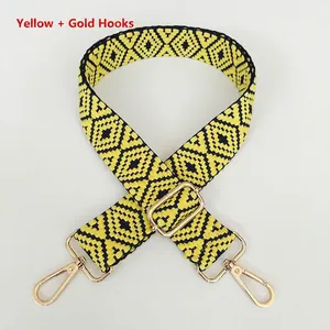 Close-up of thick woven bag strap with yellow diamond pattern and gold metal hooks