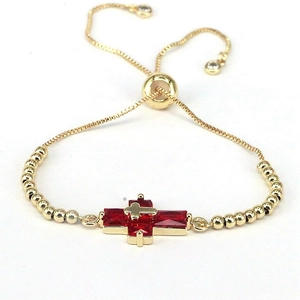 Adjustable golden beaded bracelet with red zircon cross charm and sliding clasp closure
