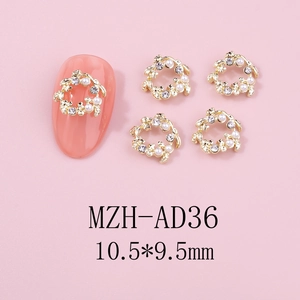 Détail macro de breloque ongle couronne dorée avec perles et strass sur fond rose