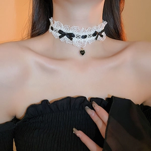 Detailed shot of white lace choker with black bows and a heart-shaped pendant