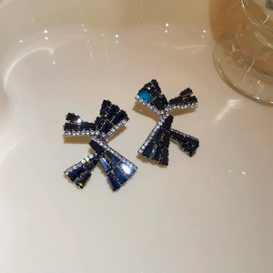 Detailed view of black ribbon bow earrings with micro-inlaid cubic zirconia stones