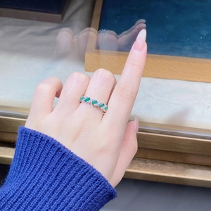 Close-up of S925 silver ring with emerald-cut green gems and sparkling clear crystals