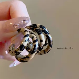 Detalle de pendientes de resina con estampado de leopardo y medida de 2,5 cm