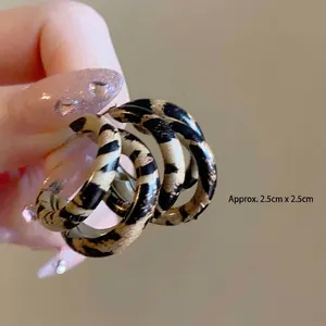 Detail shot of leopard print resin earrings showing the 2.5cm size measurement