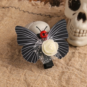 Gothic Halloween butterfly hair clip with skull and rose on rustic burlap background