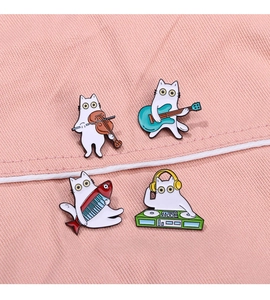 Detailansicht von vier Katzen-Emaille-Pins mit Musikinstrumenten auf rosa Stoff