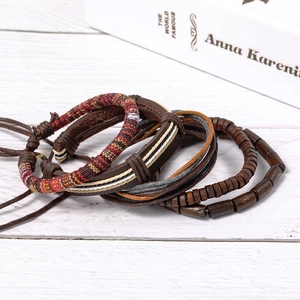 Vintage stackable bracelet set with hand-woven leather and wooden beads on a rustic surface