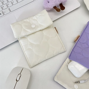 Detailed view of quilted heart pattern pouches in white and purple with button closures