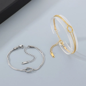 Detail of double-layer stainless steel snake chain bracelet with knot design in gold and silver