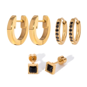 Three pairs of gold stainless steel hoop earrings and black zircon studs set on white background
