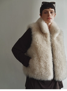 Detail of faux fox fur vest showing the high collar and plush texture in beige