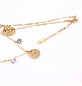 Detail of layered gold necklace showing lobster clasp and S.steel hallmark tag