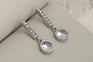 Macro detail of silver drop earrings with rectangular bars and round cubic zirconia stones