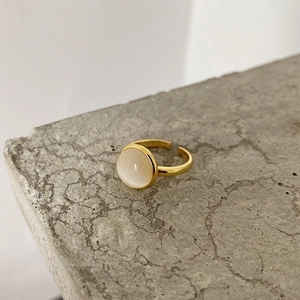 Detail of adjustable gold ring with round cat's eye stone on minimalist stone base