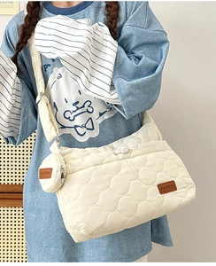Gros plan sur un sac bandoulière matelassé crème avec petit porte-monnaie assorti