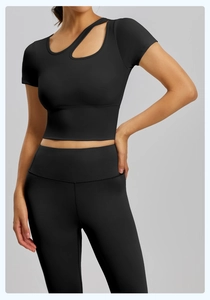 Dettaglio del set yoga nero con top corto asimmetrico e leggings sportivi a vita alta