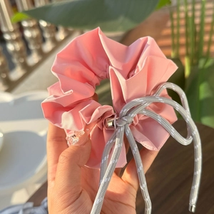 Detail of pink plaid scrunchie with grey braided drawcord and metallic hardware ends