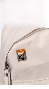 Detail of artistic black cat enamel pin inspired by The Scream on white canvas bag