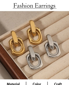Fashionable gold and silver geometric buckle earrings displayed in a beige jewelry box
