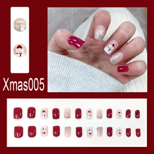 Detail of Christmas press-on nails with Santa Claus and snowflake designs on glossy resin