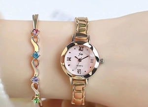 Close-up of rose gold women's watch with pink Roman numeral dial and gemstone bracelet
