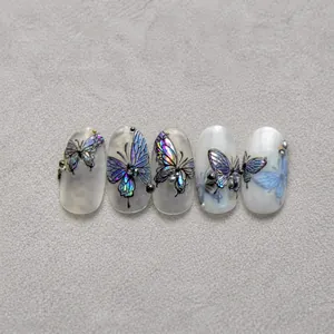 Detail of 3D laser butterfly nail stickers with pearls on pearl white gradient nails