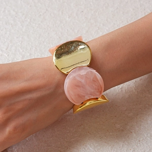 Dettaglio del bracciale con segmenti in resina marmorizzata rosa e metallo dorato
