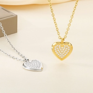 Detailed view of heart-shaped pendants with pave-set rhinestones in gold and silver finishes